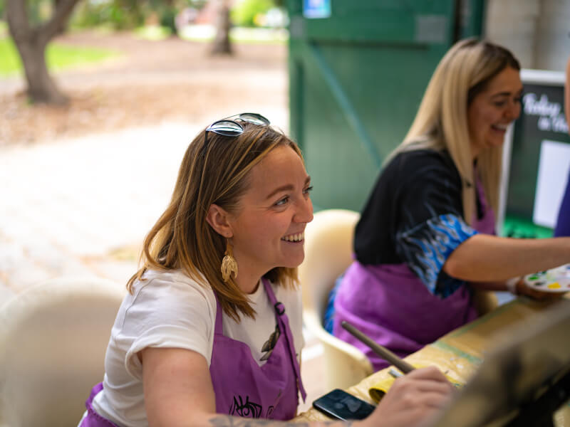 women smiling at painting class